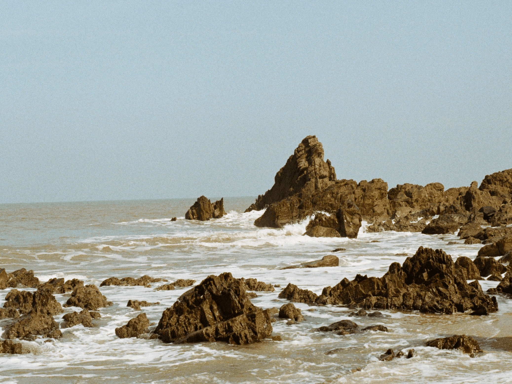 A rocky coastline at low tide — the sea breeze and the town we grew up in